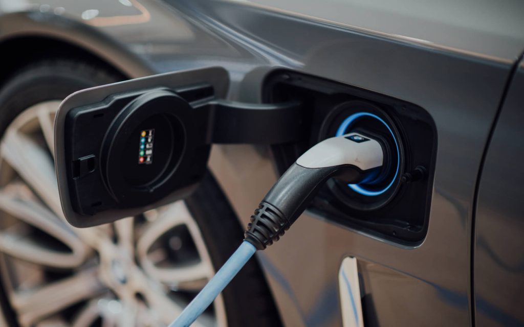 A close-up of an electric vehicle charger plugged into an electric car.