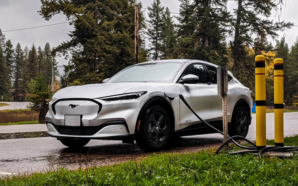 An electric Ford mustang being charged on an overcast day – links to go electric bc EV website