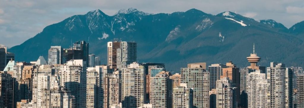 Vancouver city skyline with mountains in the background on a clear day.